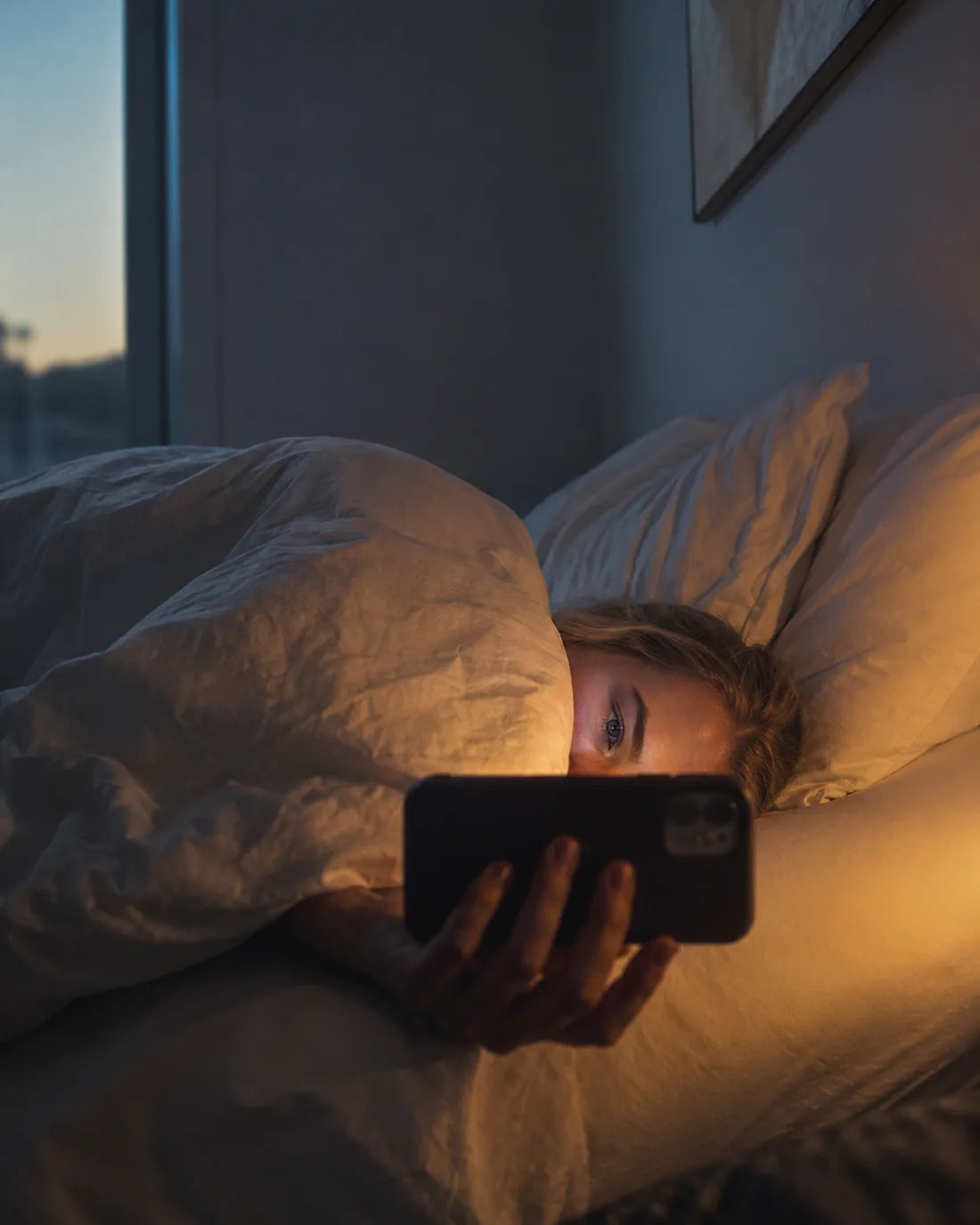 Frühmorgens im Bett scrollen, das Gesicht vom Handy beleuchtet