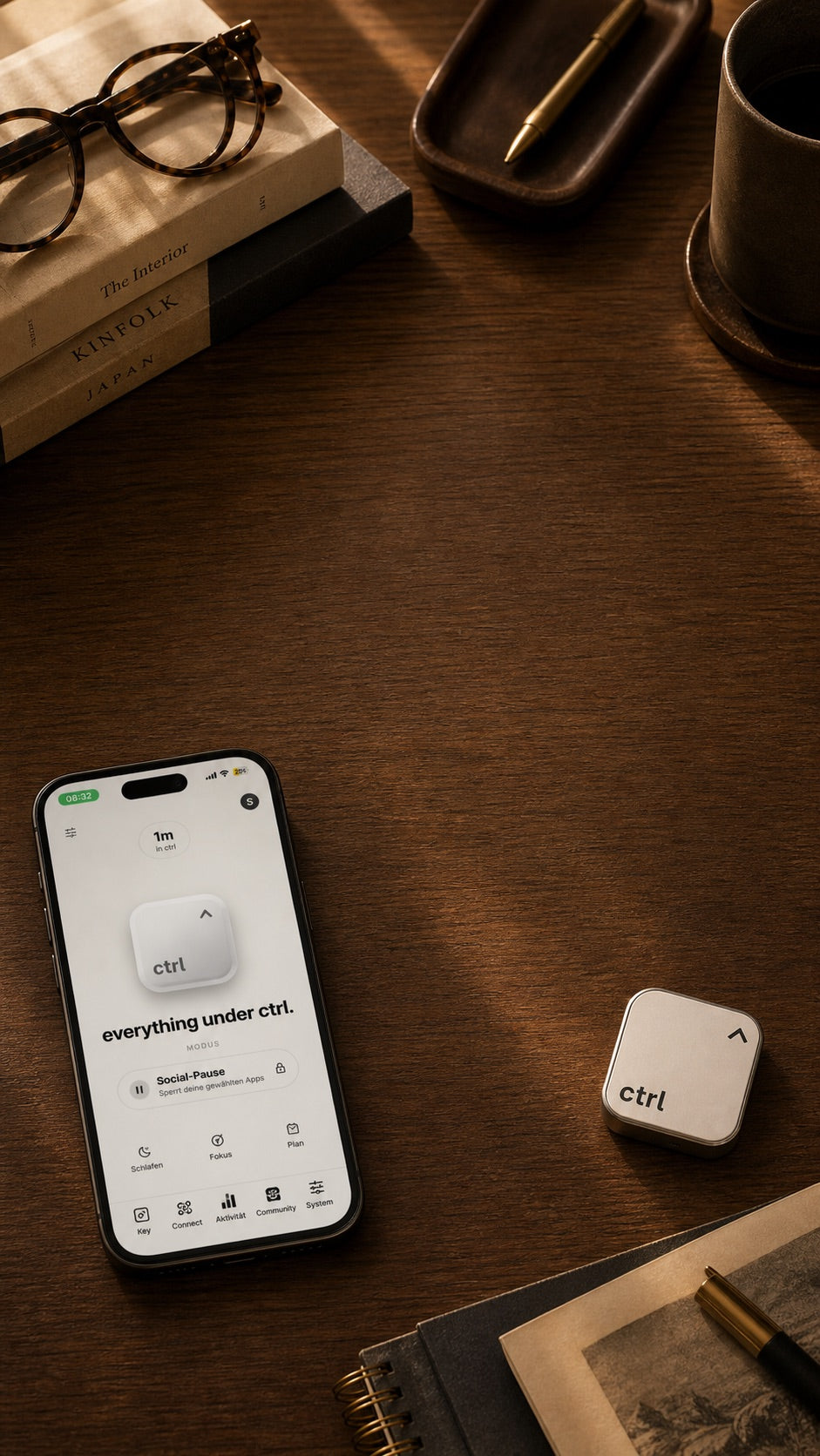 iPhone mit dem Home-Screen der ctrl App neben dem ctrl key auf einem Holzschreibtisch