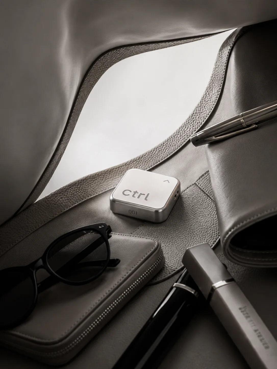 Der ctrl key in einer Ledertasche neben Sonnenbrille und Portemonnaie